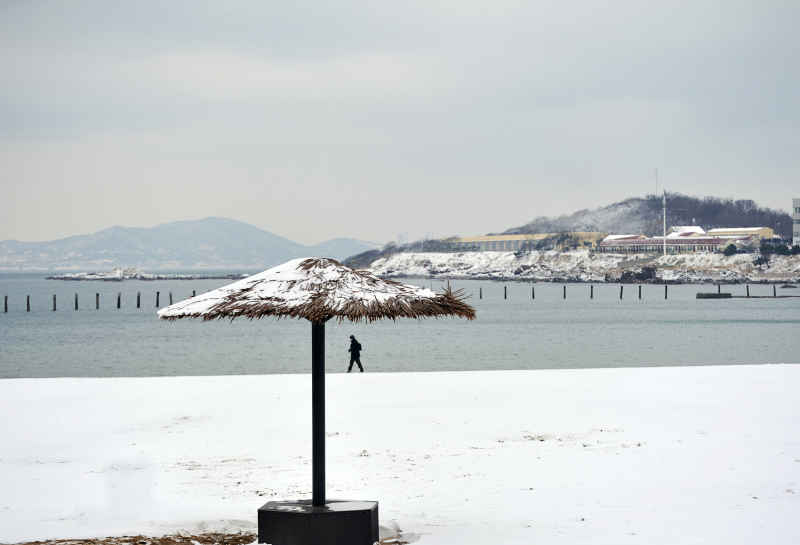 雪后走在海岸的人
