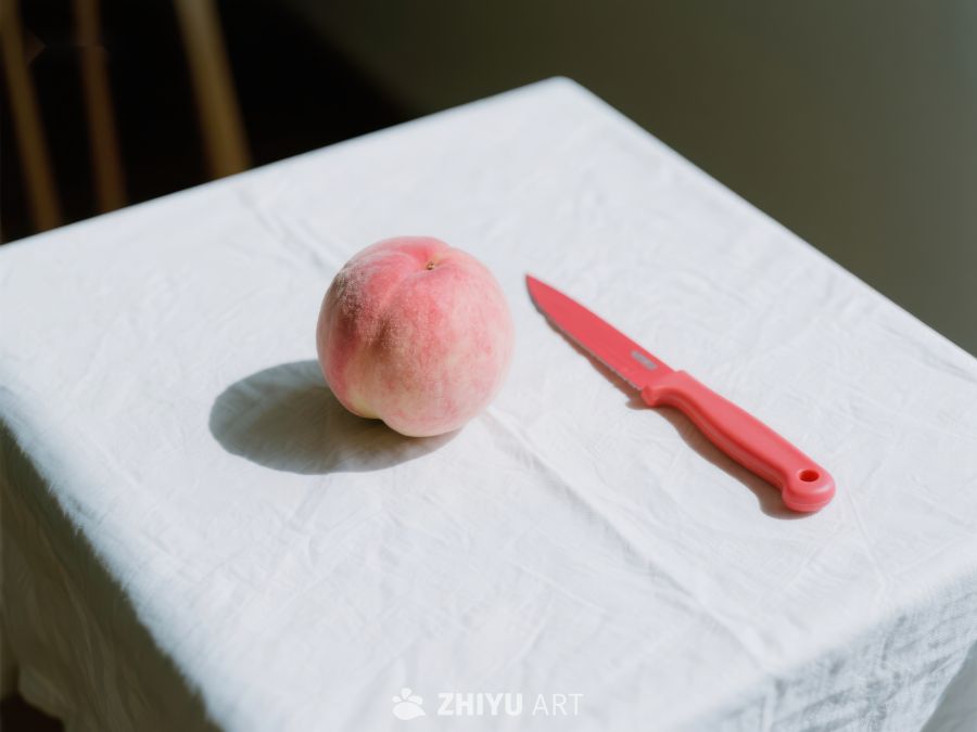 桃子与红色刀具置于白色布上 584