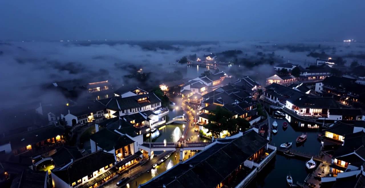 夜晚时分，无人机视角俯瞰江南水乡。黑色屋顶的新宋式