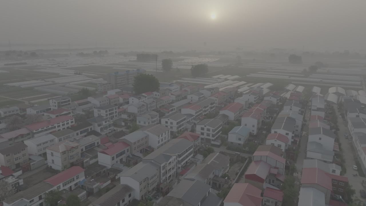 晨雾中的村庄与温室