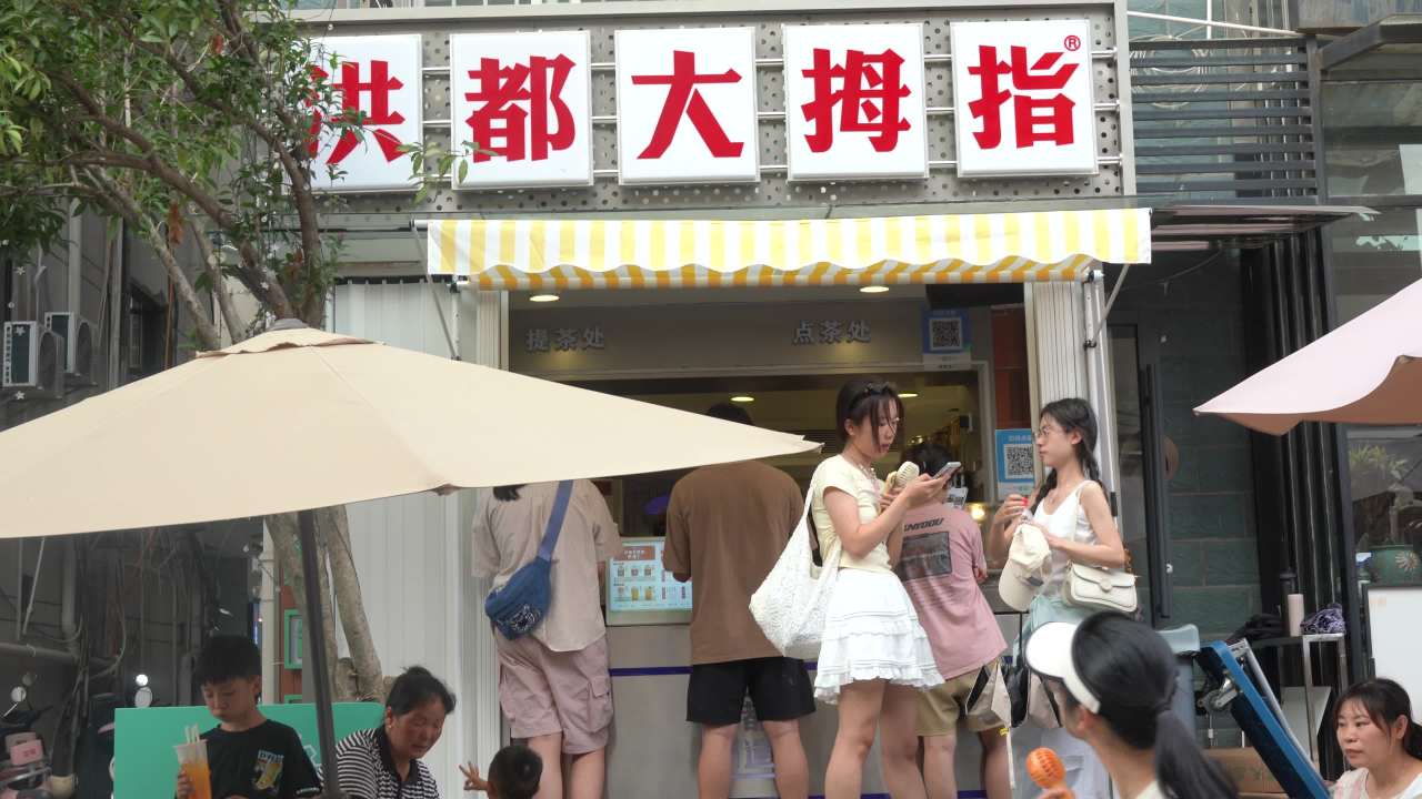 洪都大拇指奶茶店前的悠闲时光