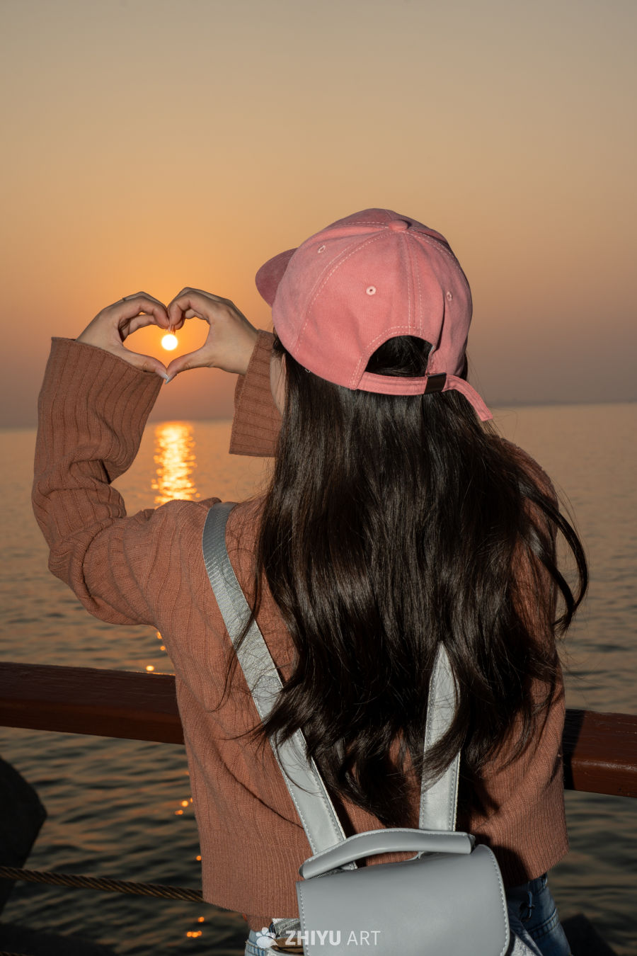 海边夕阳下的爱心手势