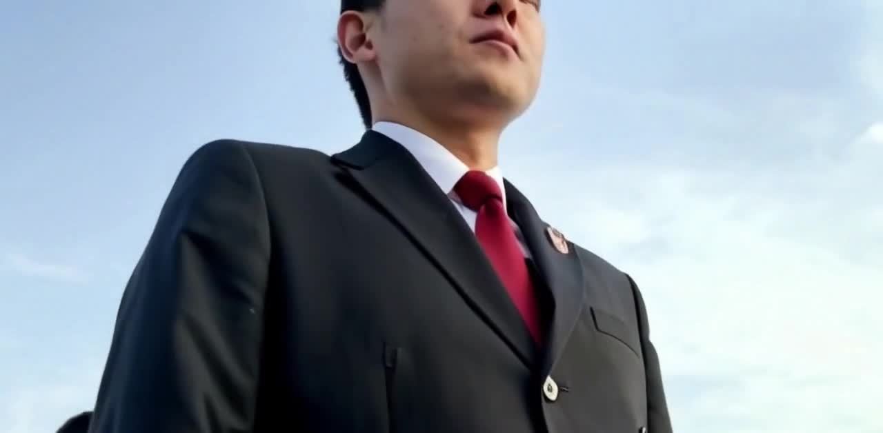 户外蓝天下西装革履抬头望天的严肃男人