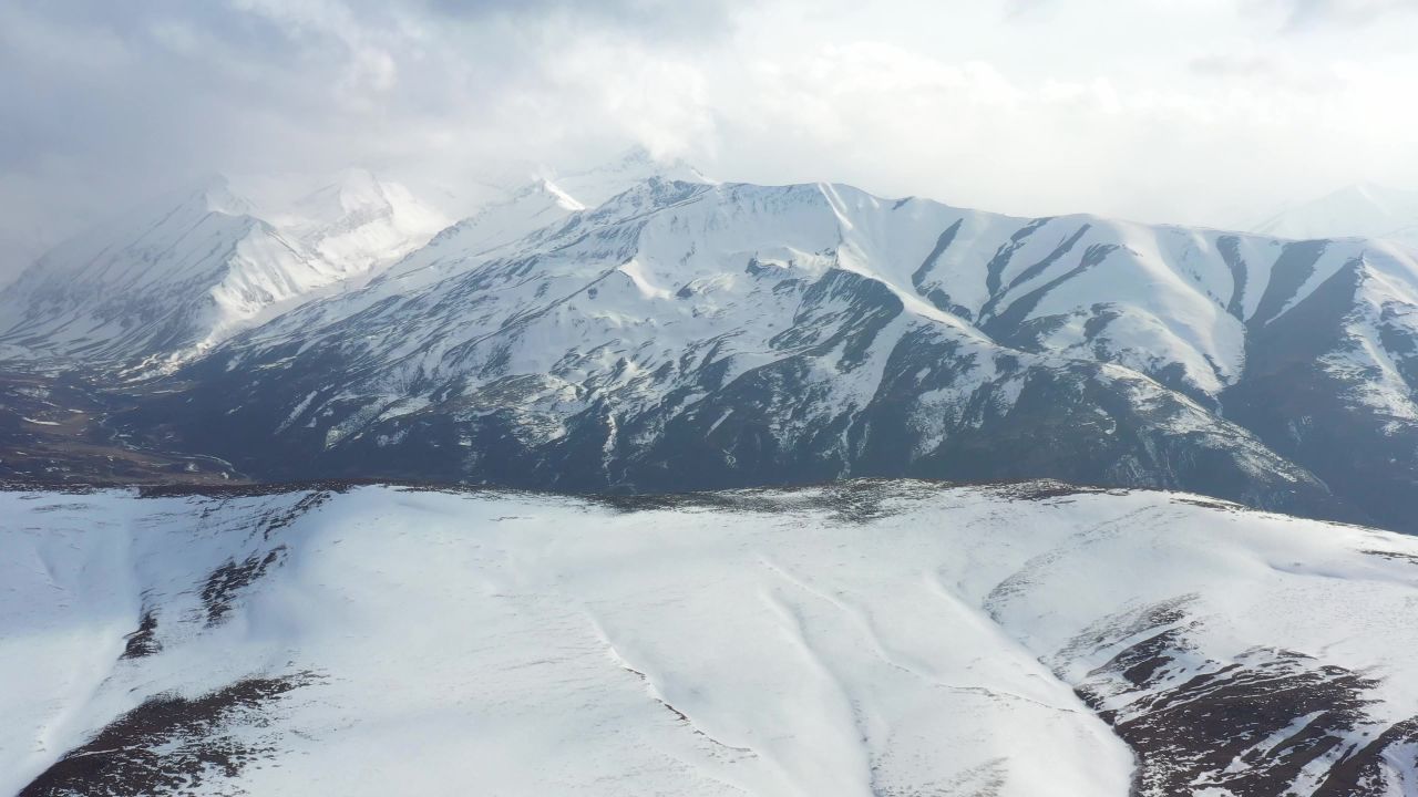 航拍风雪中的西藏洛隆县雪山风光