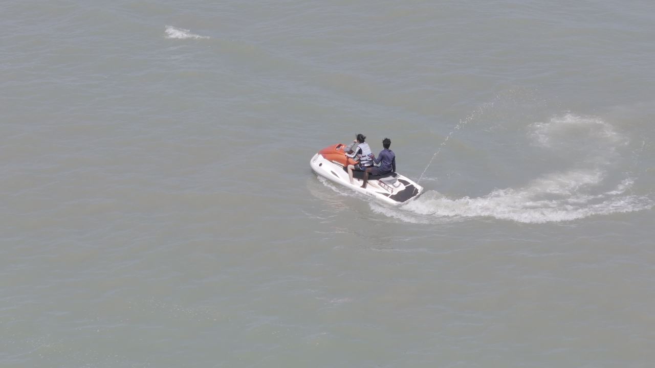 两人乘水上摩托疾驰海面