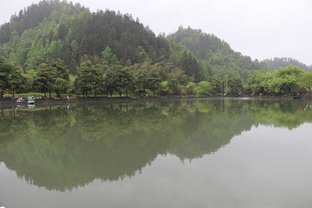 西递村旁，烟雨之中，湖面倒影着的绿水青山