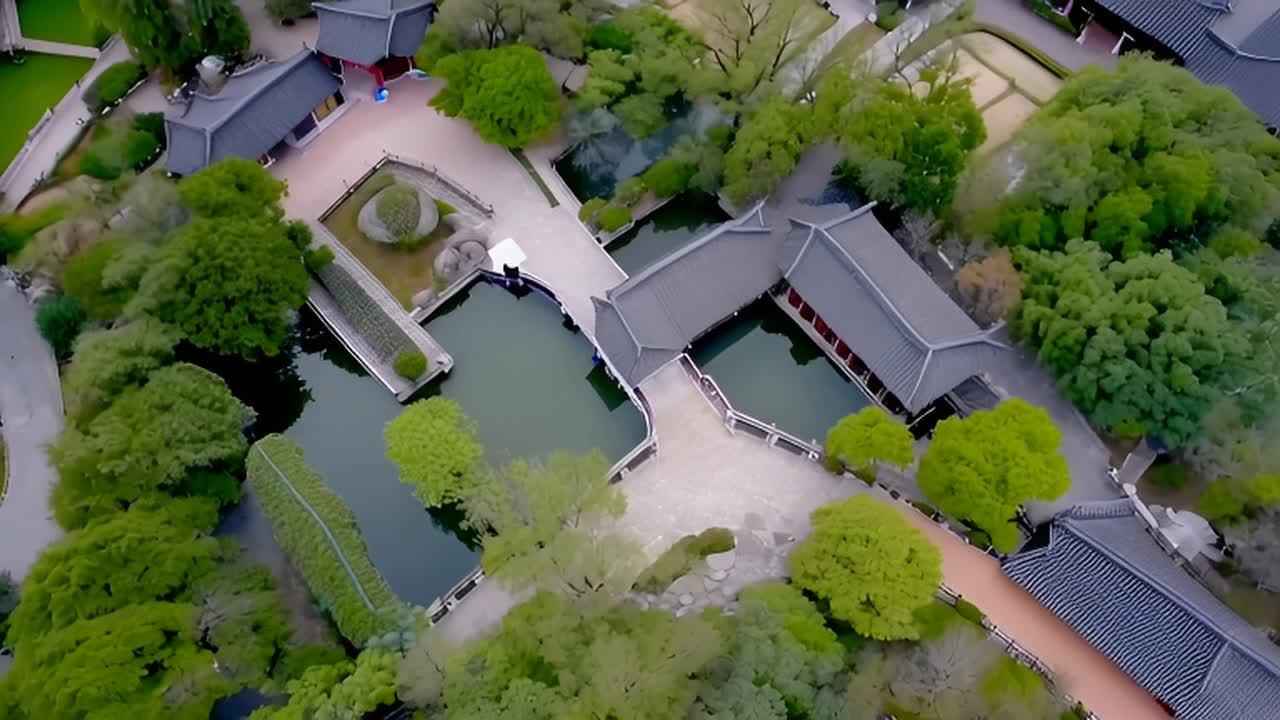 从高处俯瞰，园林建筑群分布在树木和水池之间，白色的