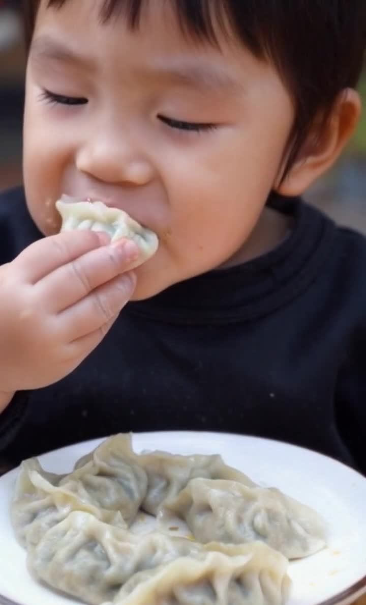中国小孩吃饺子正往嘴里送