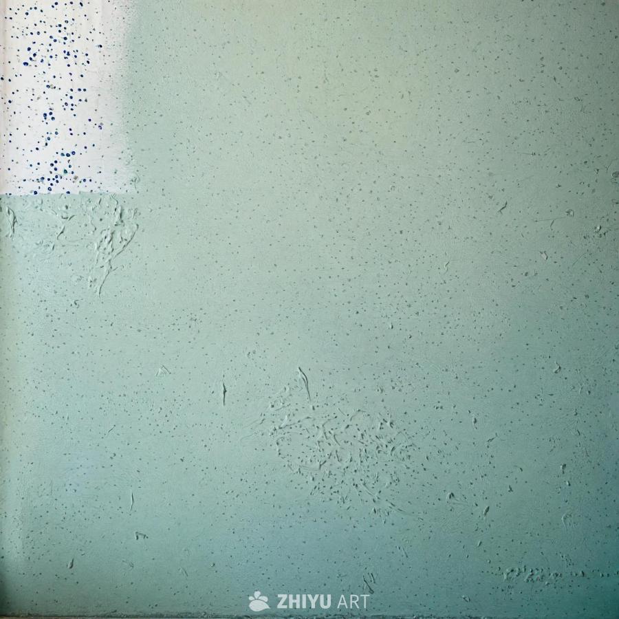 一面大的白色墙壁，略带绿色色调。墙壁表面有纹理和斑