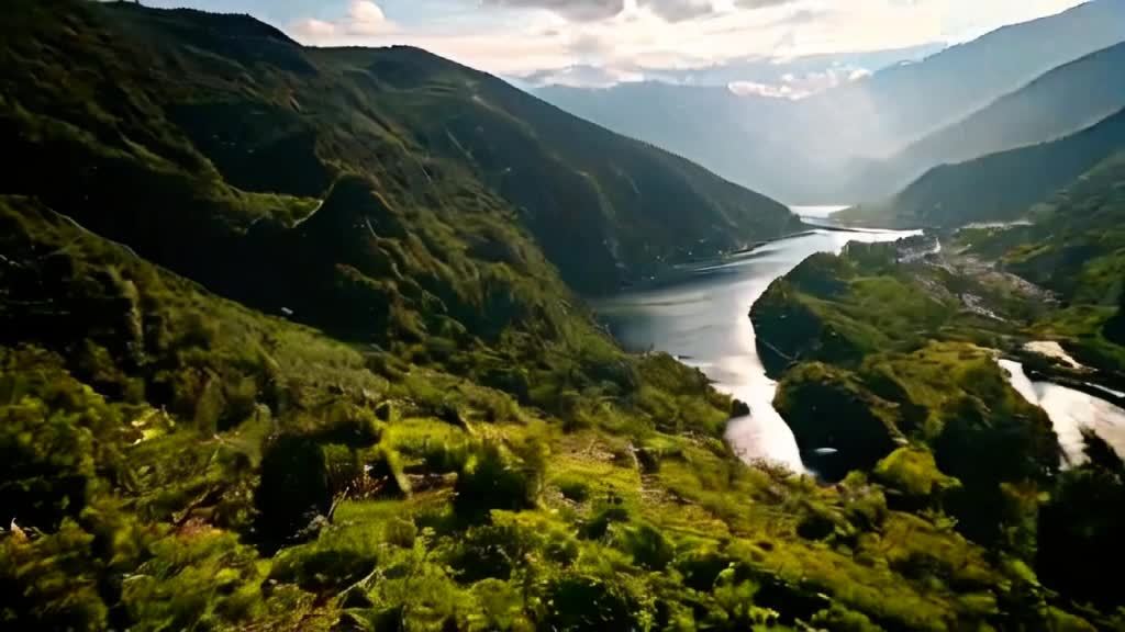 群山环绕，山体覆盖绿色植被，山脚下有河流蜿蜒流淌，