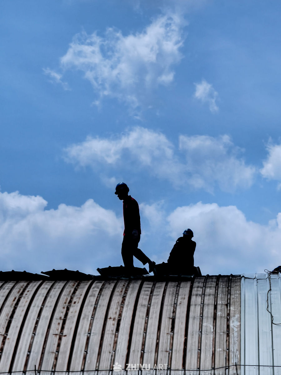 屋顶劳作：蓝天下的剪影