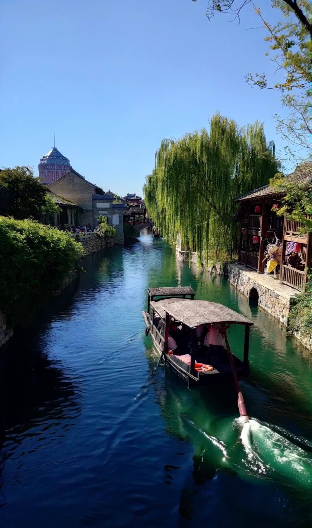 古镇河道游船，柳树成荫，水清景美怡人。