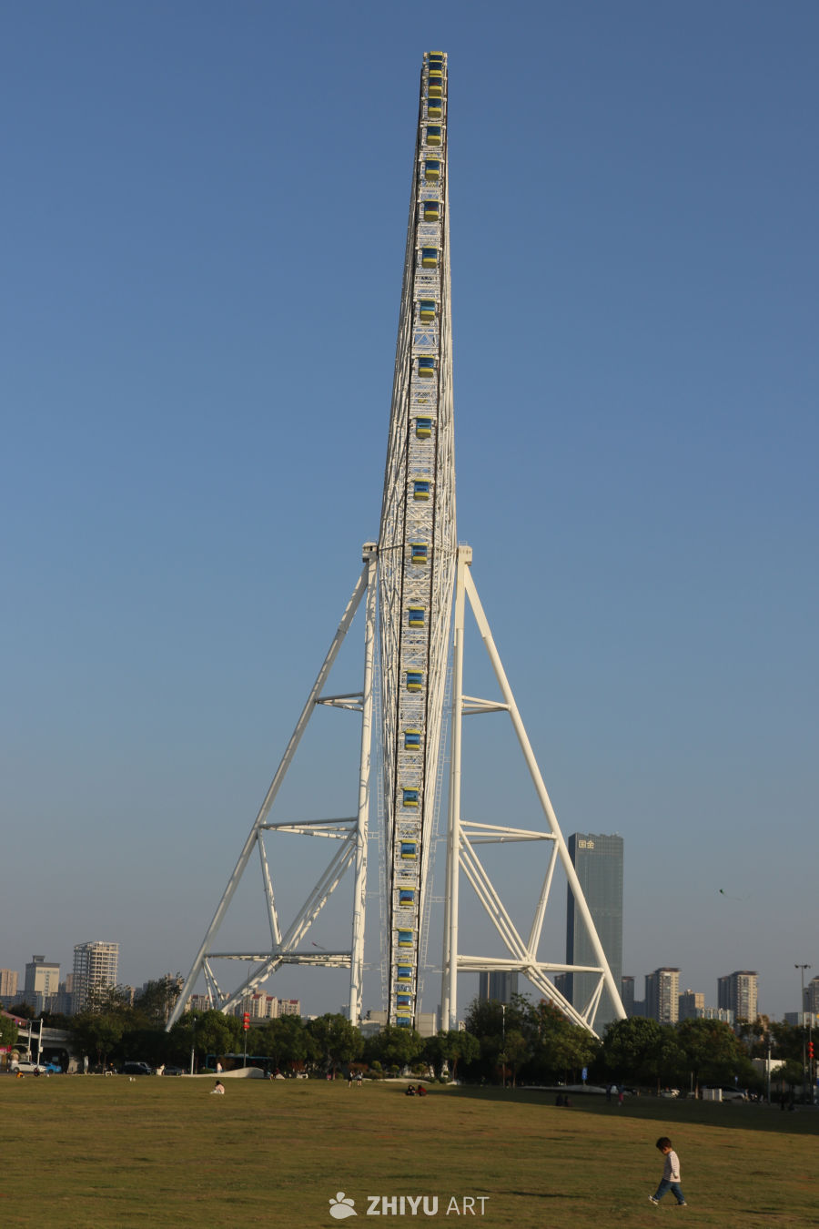 城市摩天轮与蓝天下的公园