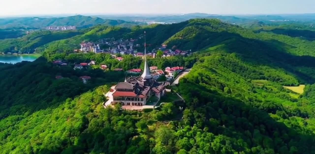 翠绿的山峦连绵起伏，山顶矗立着一座具有中国传统风格