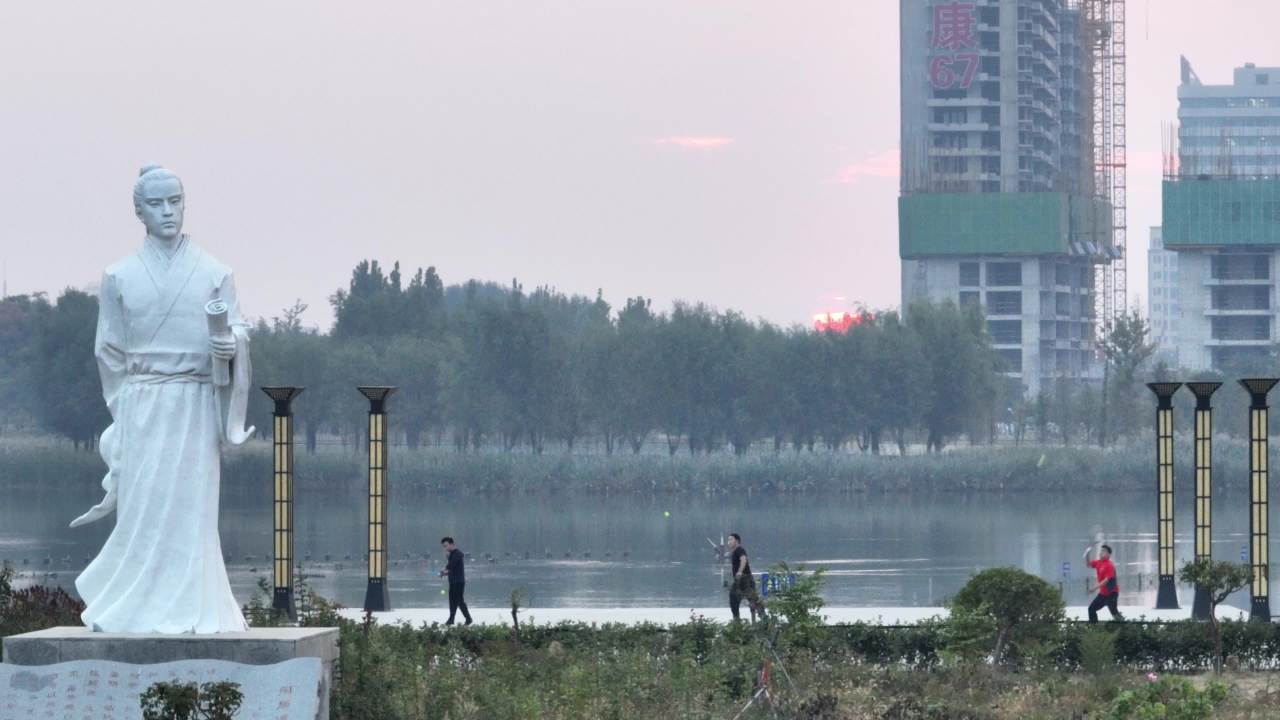 湖畔雕像与行人