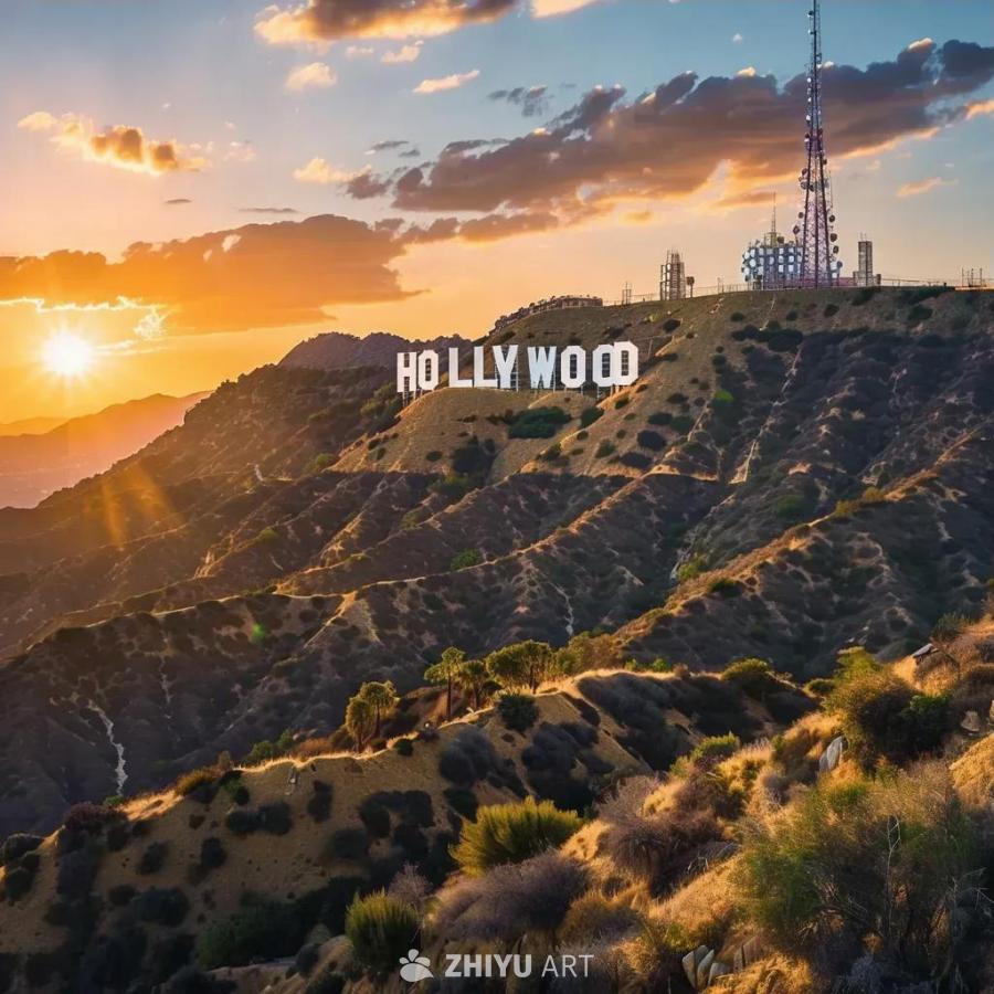 山顶上竖立着白色的“HOLLYWOOD”字样，在夕