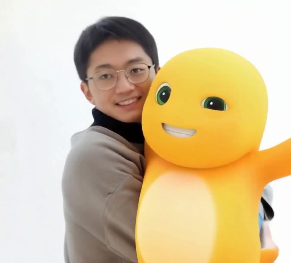 眼镜男与卡通橙色小恐龙的合影