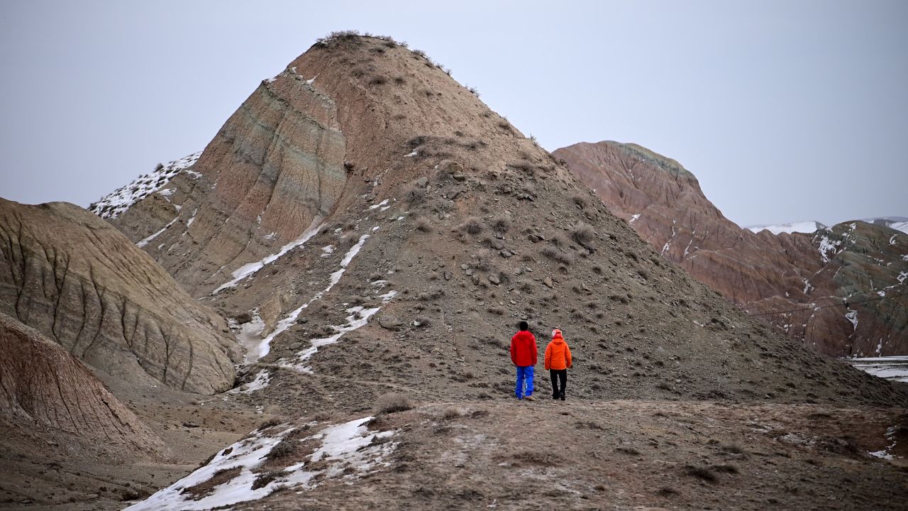 两个男人前往丹霞地貌山峰