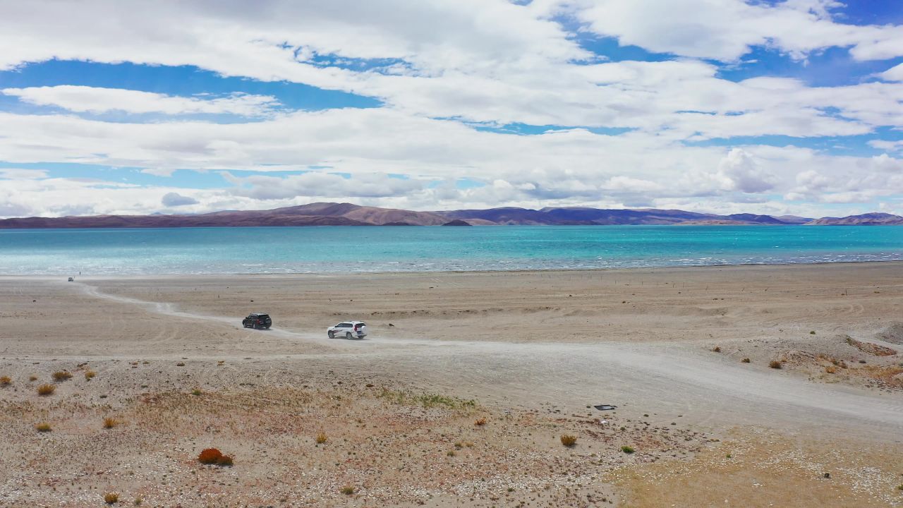 航拍越野车驶向西藏阿里拉昂错湖边