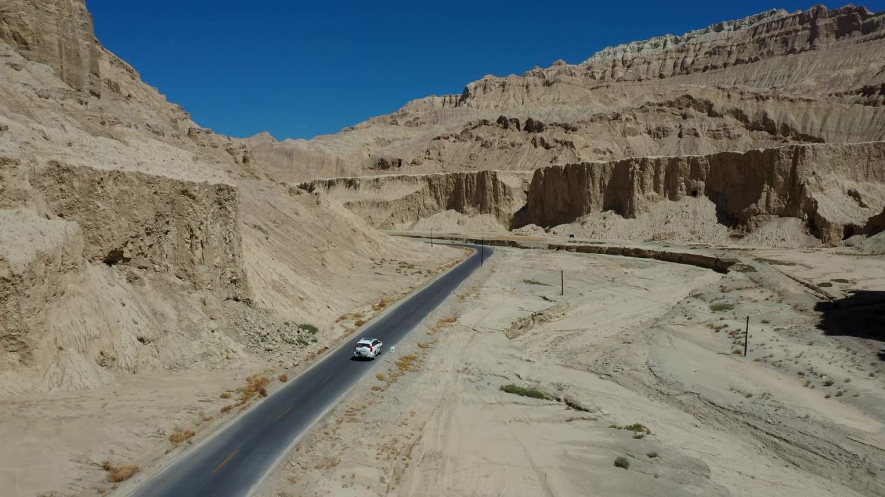航拍汽车行驶在札达土林中的公路上