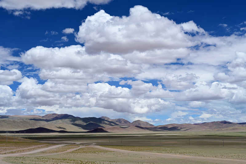 西藏阿里地区蓝天白云下广袤的草原和山脉