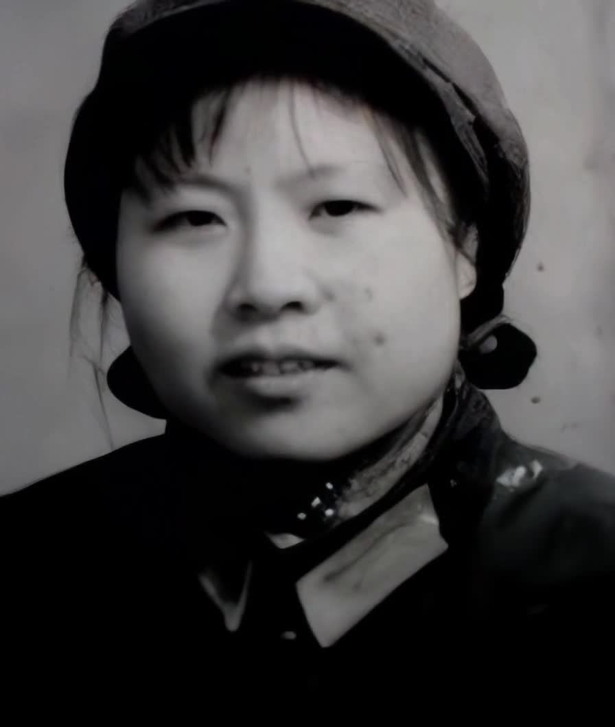 一位女性的黑白照片，她留着短发，戴着一顶帽子。照片