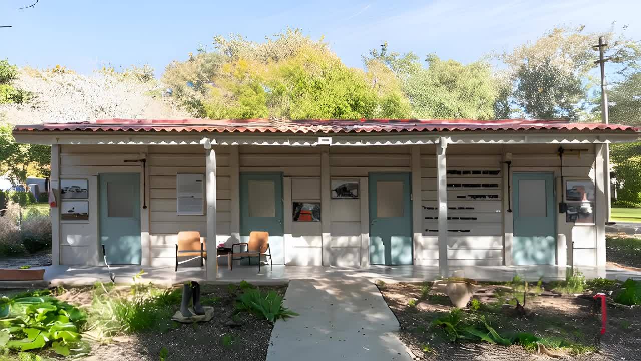 一栋白色的平房建筑，屋顶是红色的波浪形瓦片。建筑前