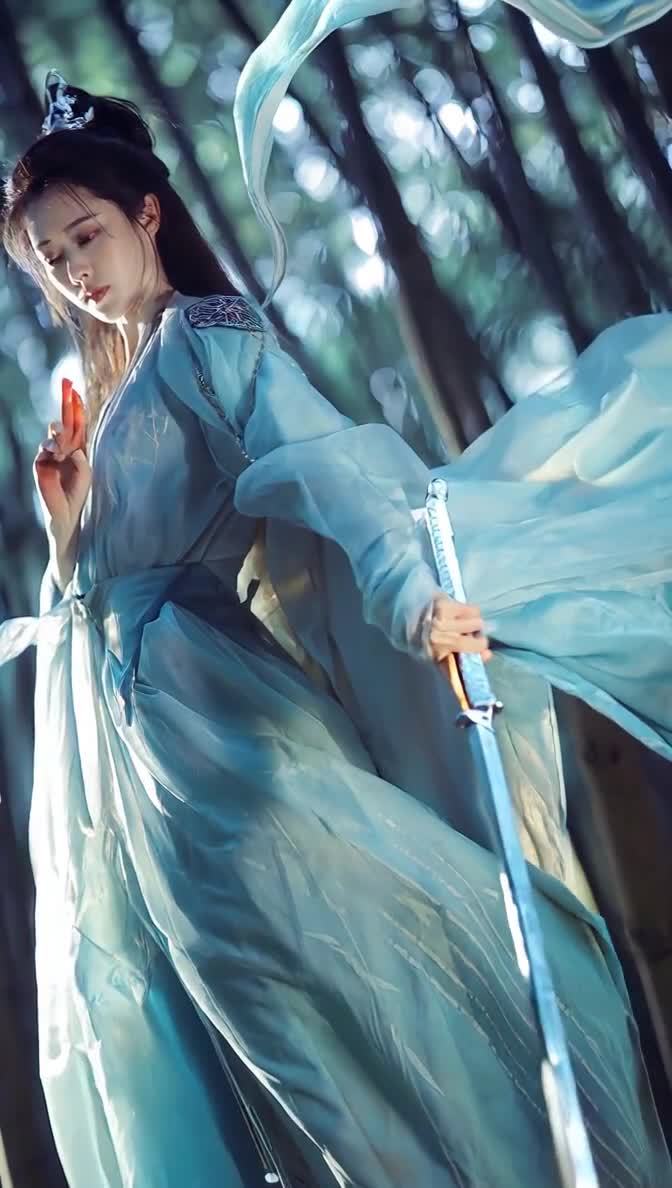 一位身穿浅蓝色古装的女侠客缓缓转头，看向镜头。女侠