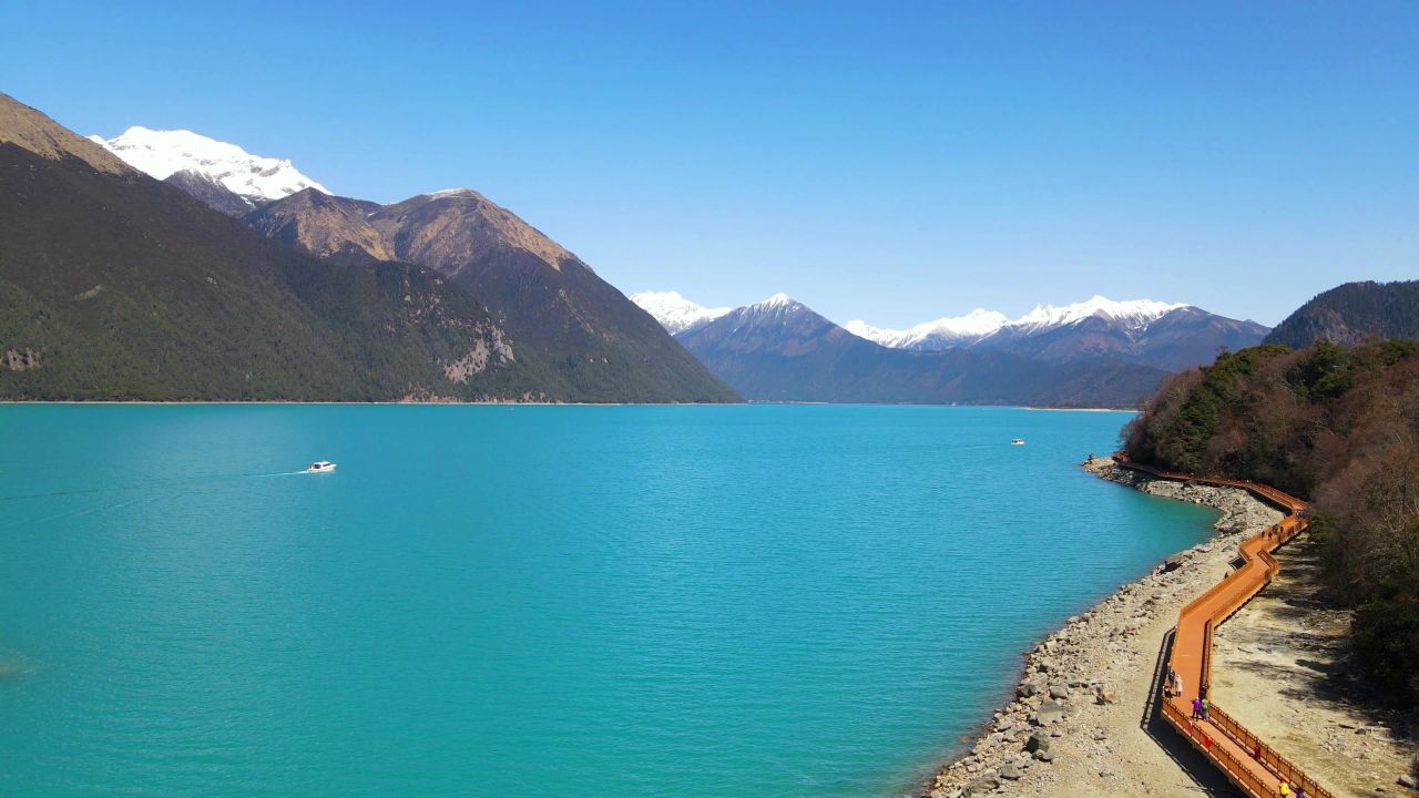 航拍西藏林芝青山蓝天下绿宝石般的巴松措湖面