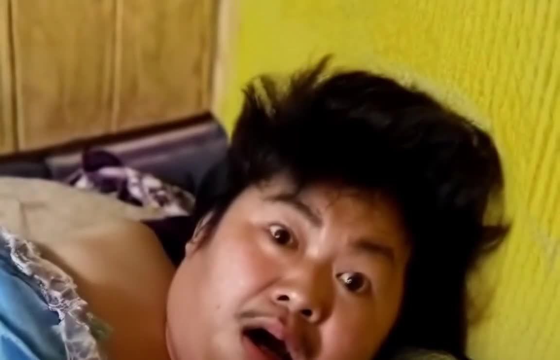 床上蓝床单黄色墙边的男子