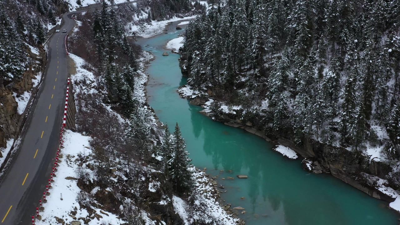 汽车行驶在雪天的帕隆藏布江河谷