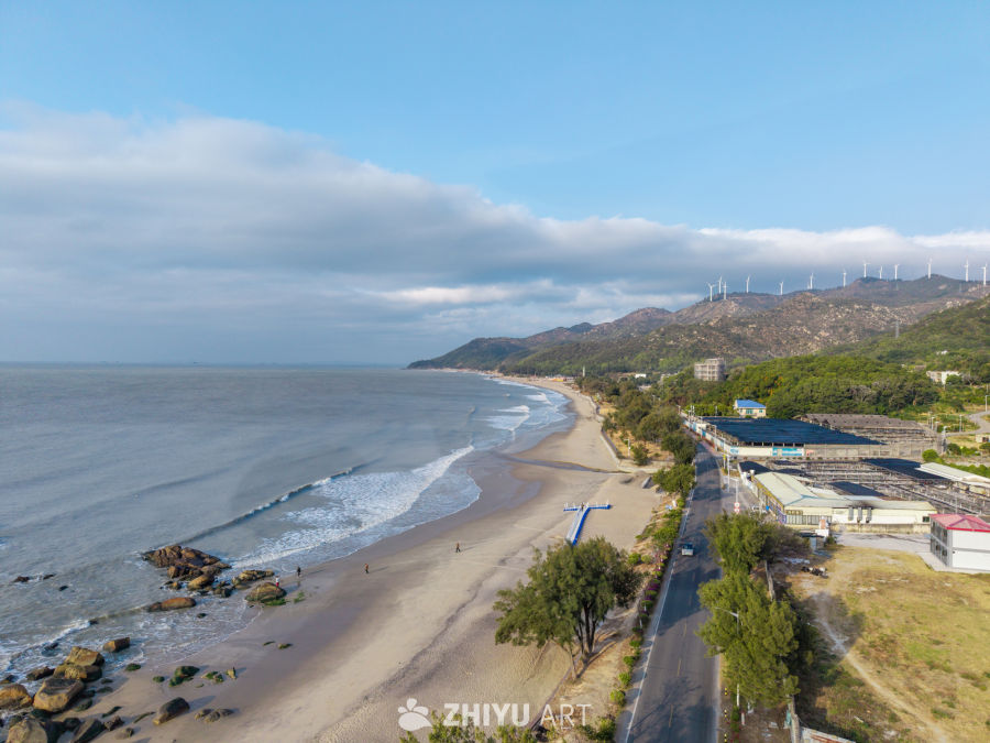 海滨风光：青山与风车的和谐画卷