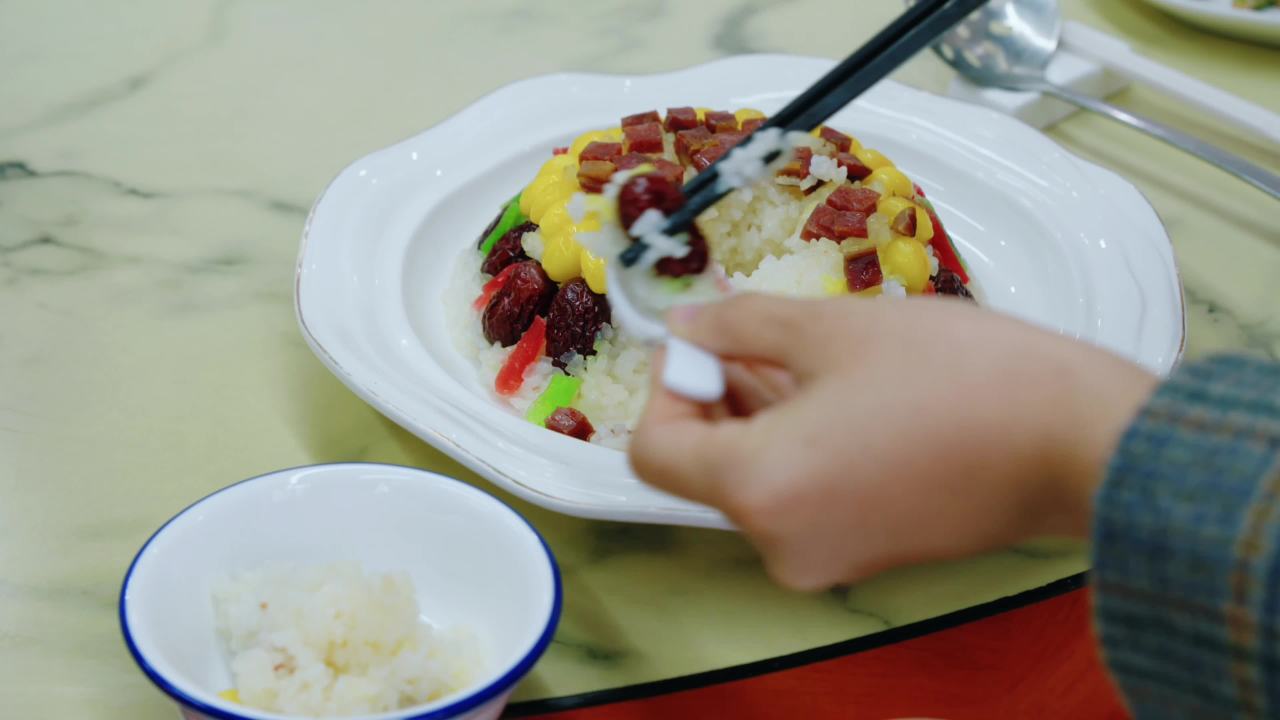 用筷子夹彩色米饭的瞬间