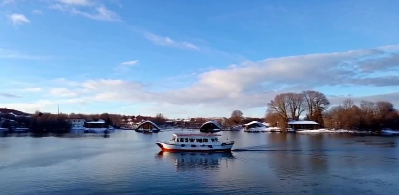 雪岸晴空游船荡漾水波间