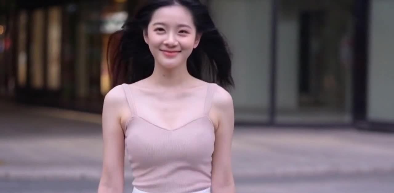 微笑吊带裙女子街头漫步