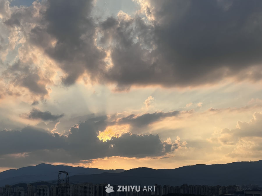 夕阳穿透云层的城市剪影