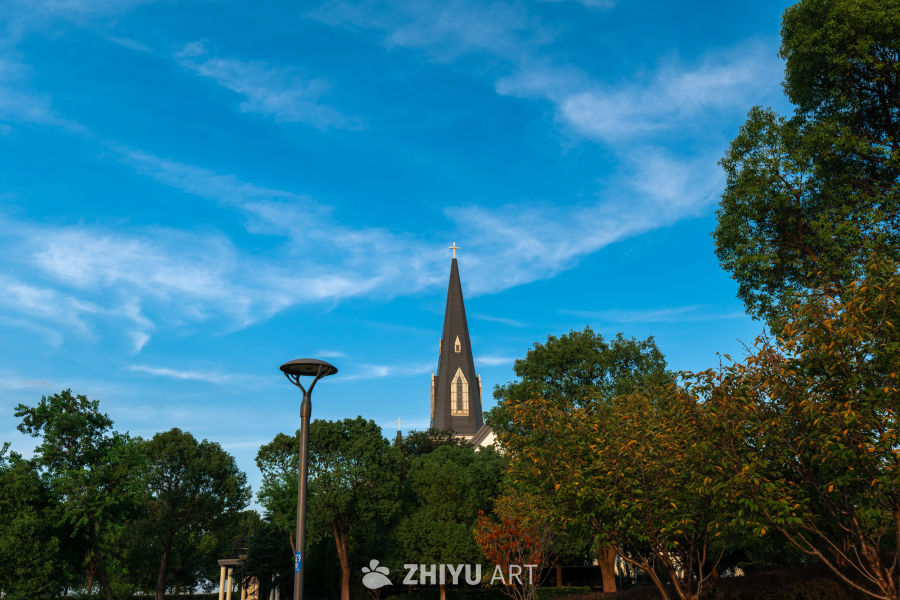 教堂尖塔与蓝天绿树