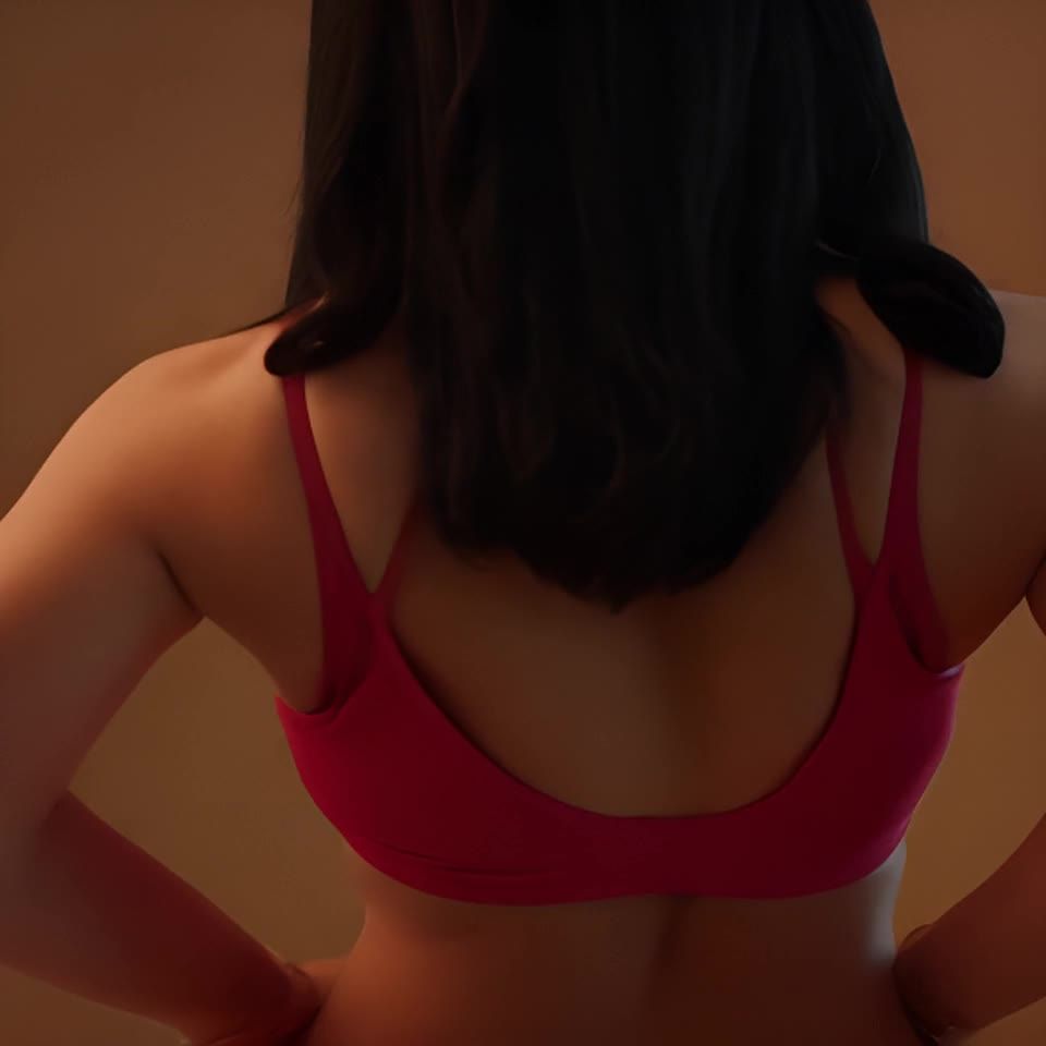 一位女性有着黑色的长发，穿着一件粉红色的吊带背心，