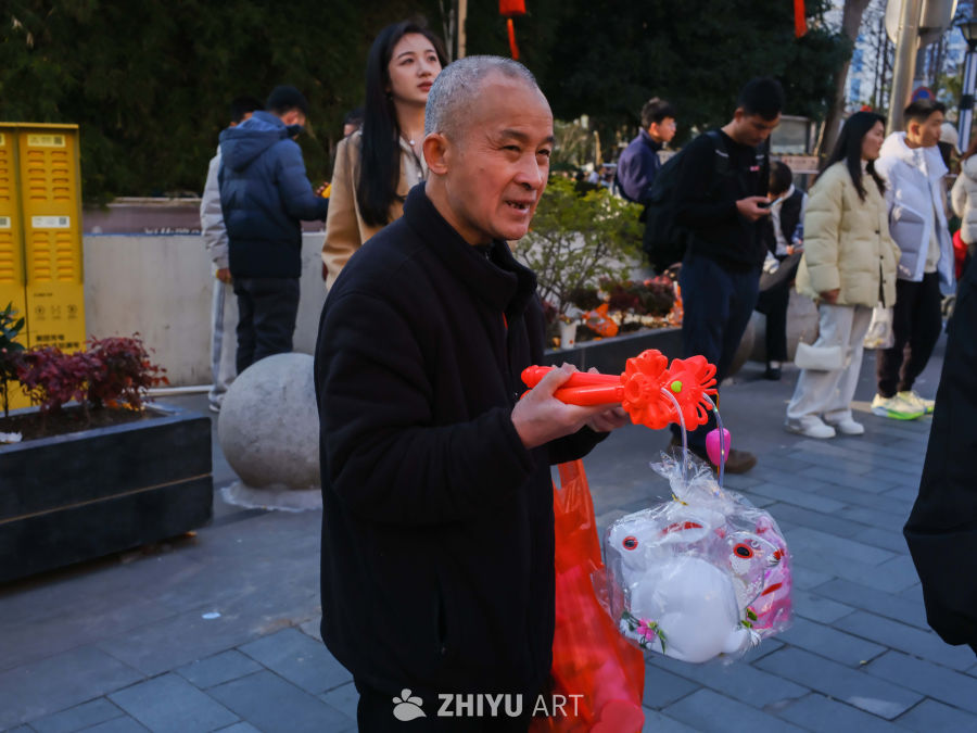 街头老人手捧玩具微笑