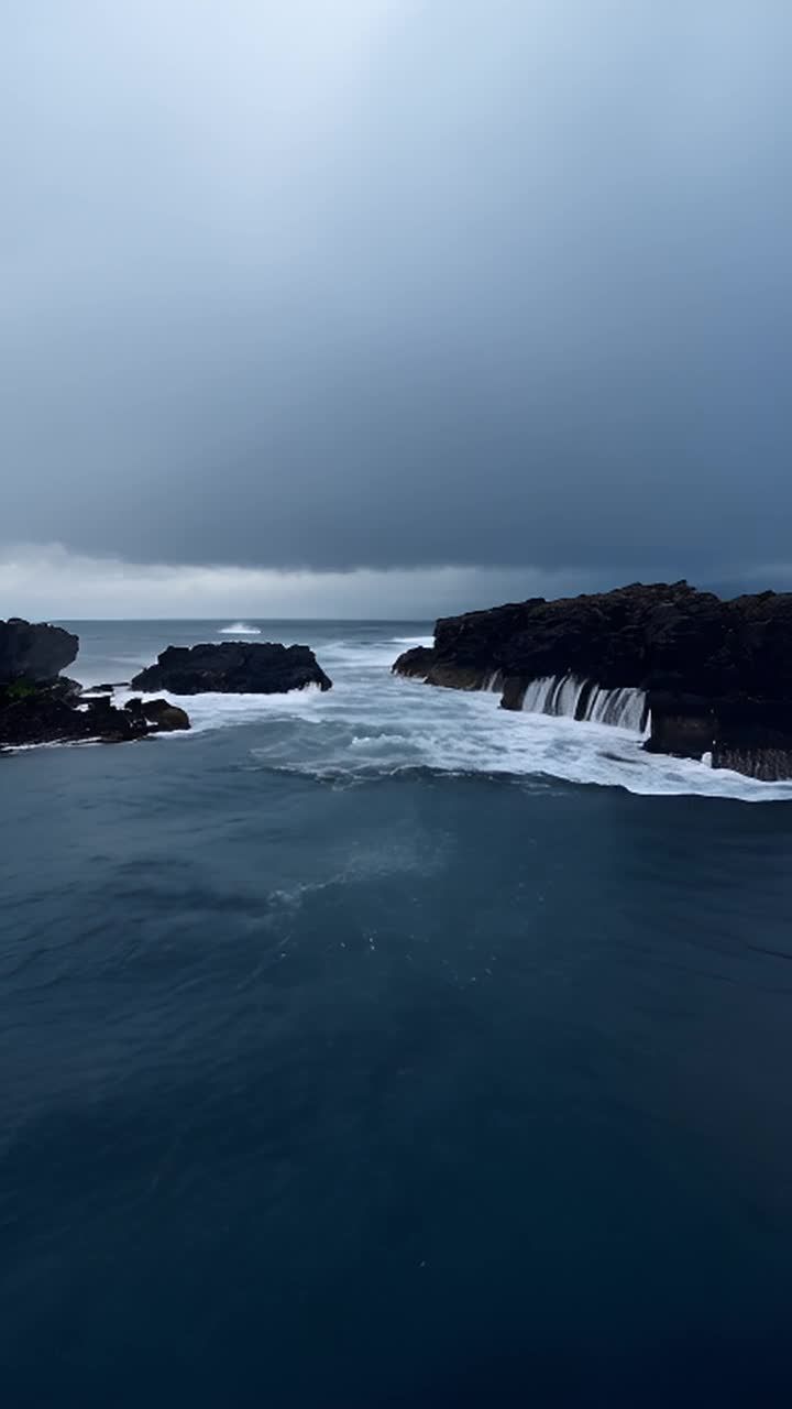 海面上，波涛汹涌，海浪拍打着深色的、不规则的岩石。