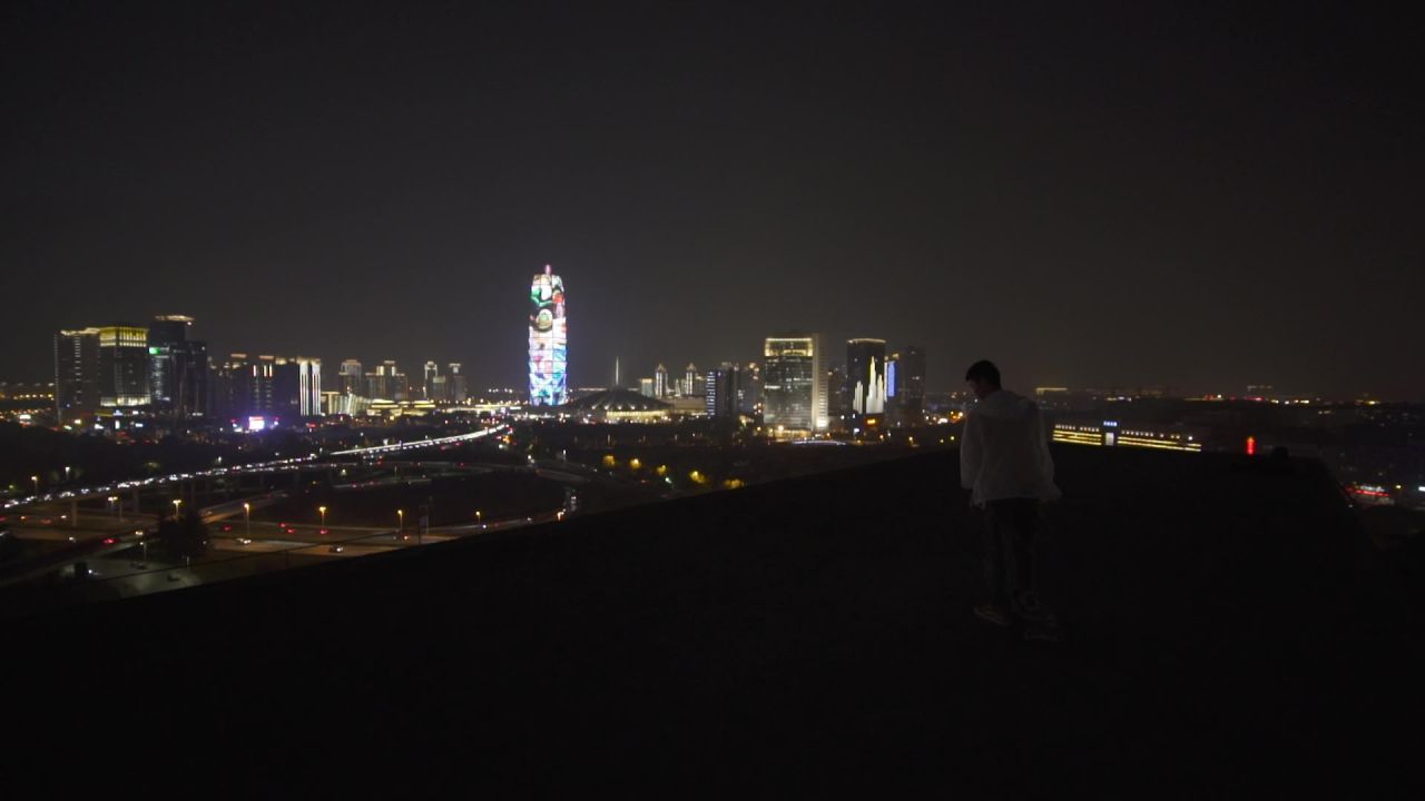 男子楼顶滑板城市夜景CBD郑州大玉米剪影