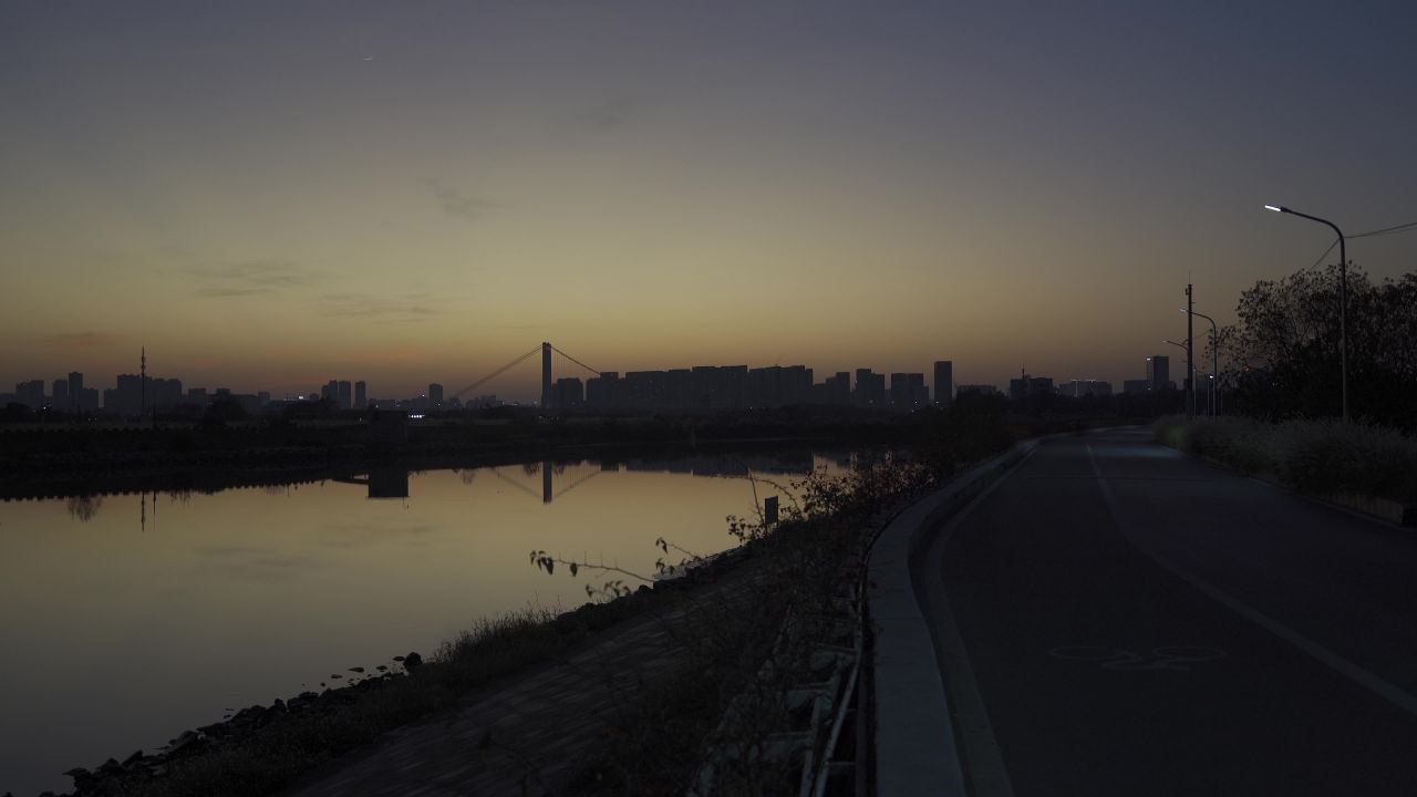 全景夕阳下低照明度的城市水库旁