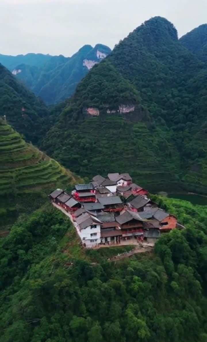 山谷中梯田环绕的村庄，房屋错落有致。