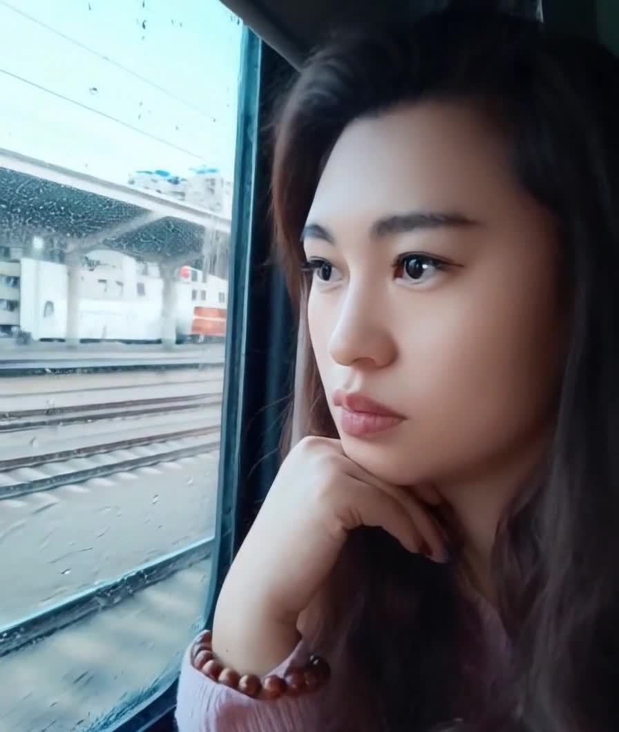 美女高铁车窗凝望，车站景象飞逝而过。