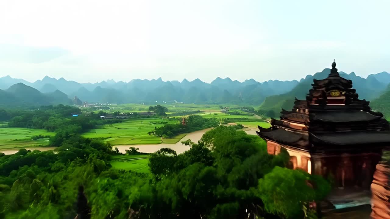 远景镜头呈现出绿色的稻田和山脉，远处有连绵起伏的山