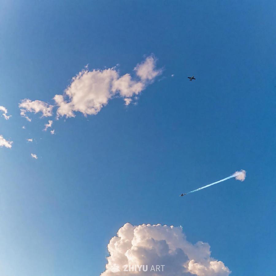 蔚蓝的天空上，散布着几缕稀疏的云彩。天空中，一架飞