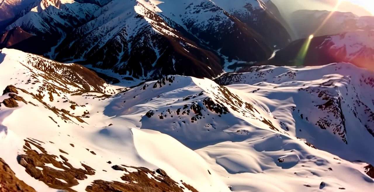 夕阳下的雪山山脊航拍壮丽景色