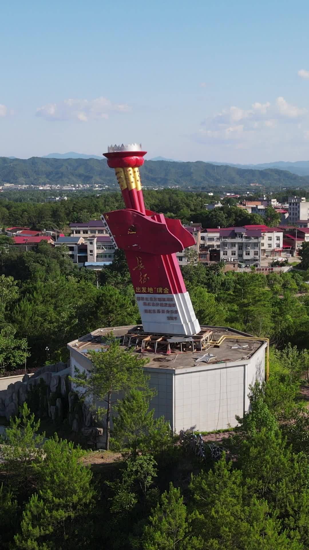 红色雕塑与山城风光