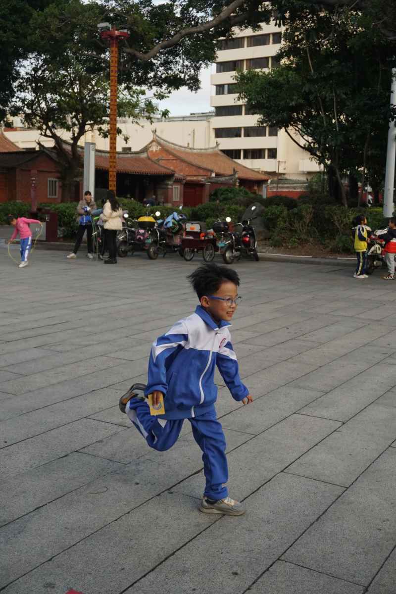 公园里穿校服奔跑的小男孩