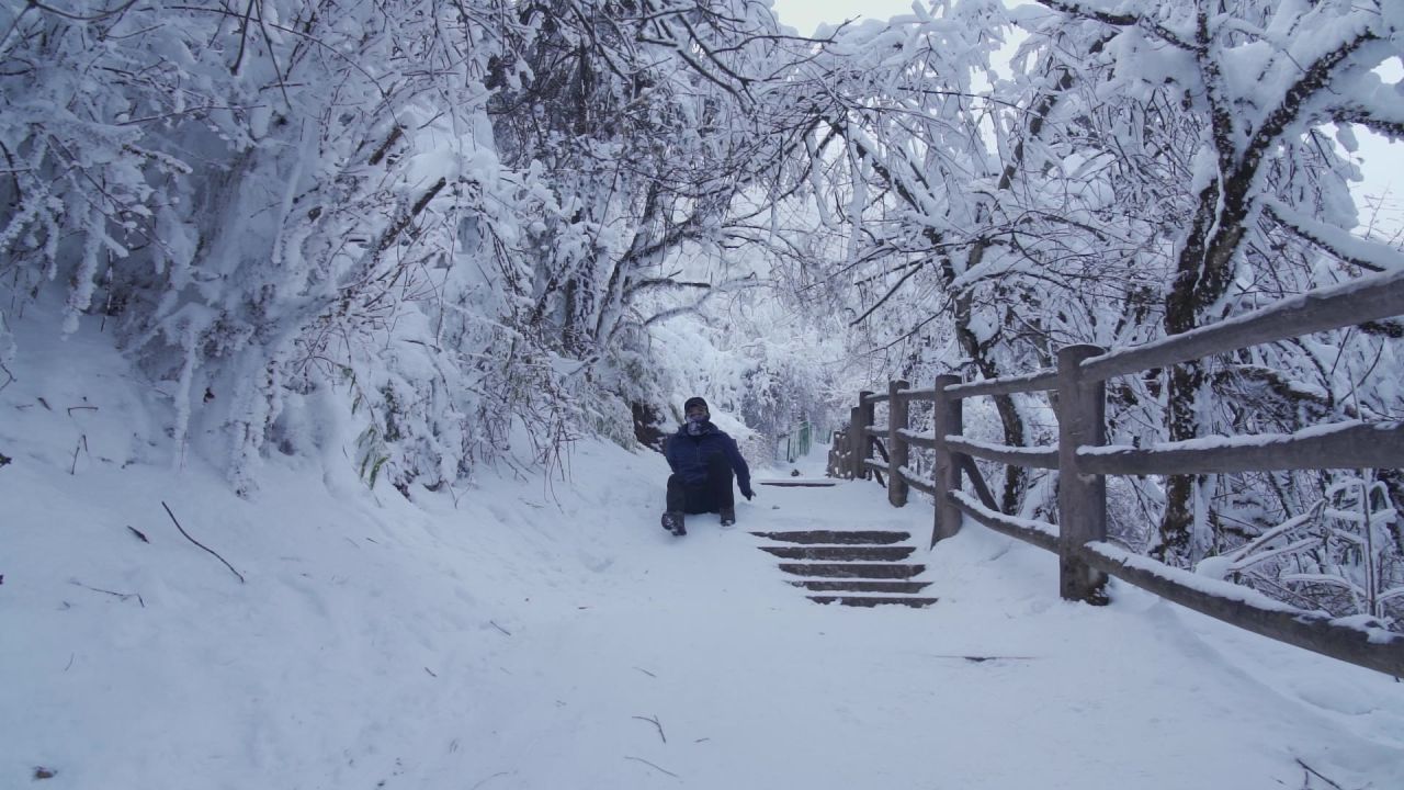 男人从雪后倾斜的登山步道滑下